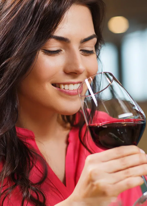 Женщина держит бокал вина